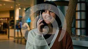 Woman happy talking phone lady speaking with smartphone smile female answer call girl calling indoors in shopping mall