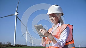 Woman with hard hat against wind turbine