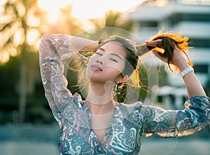 Woman with hard sunflare on with Beach Resort on the background for Summer Beach relaxation concept