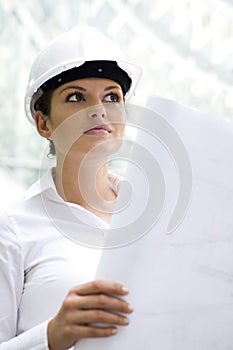 Woman in hardhat holding blueprints