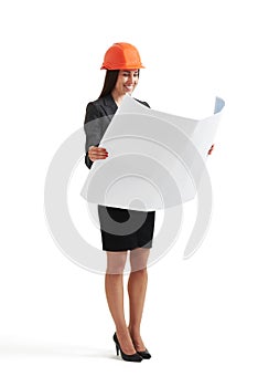 Woman in hardhat looking at blueprint