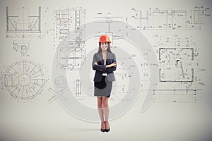 Woman in hardhat over grey wall with prints