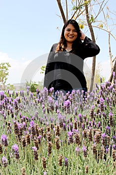 Free, happy, Latin adult woman in harmony and freedom, amid lavender flowers enjoying their beauty and aroma in a moment of relaxa