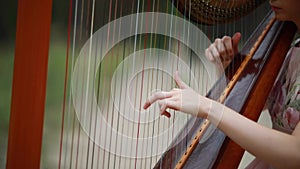 Woman harpist plays harp.