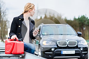 Woman has car with empty gas tank calling for help on phone