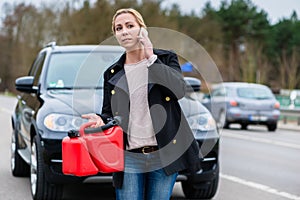 Woman has car with empty gas tank calling for help on phone