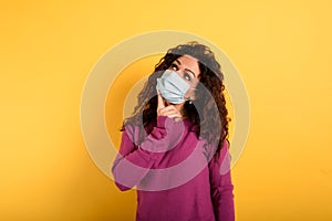 Woman has doubt about covid19 corona virus. yellow background.