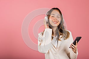 woman has fun close eyes listening music with headphones in smartphone app