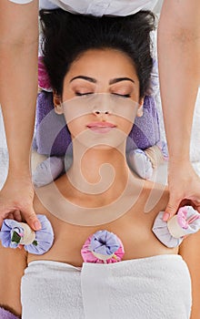 Woman has herbal ball massage in ayurveda spa wellness center