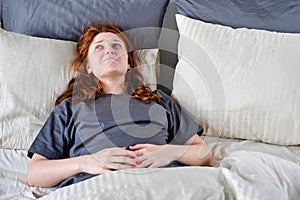 A woman has a stomach ache due to a coronavirus. Young redhead caucasian woman wtih pain in her stomach, copy space for text, copy