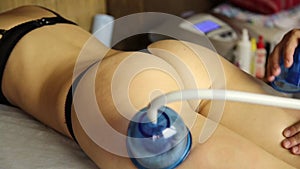 Woman has a vacuum-roller massage slimming problem areas. anti-cellulite massage. reducing the volume and improving
