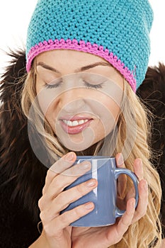 Woman hat coat mug eyes closed