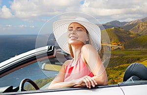 Woman in hat in convertible car on big sur coast