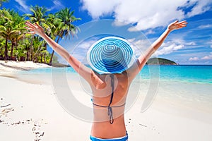Woman in hat enjoying sun holidays on the tropical beach