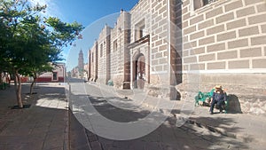 Latin adult woman with hat and glasses tourist in the city of Zacatecas Mejico discovers and walks through the colonial streets photo