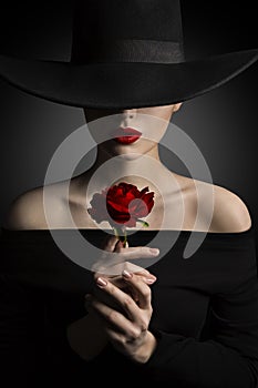 Woman in Hat holding Rose Flower in Hands, Fashion Model Beauty photo