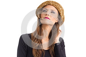 Woman in hat looks up. Person with green eyes and blonde hair.