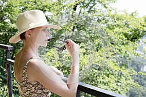 Woman in hat near fence in mountains