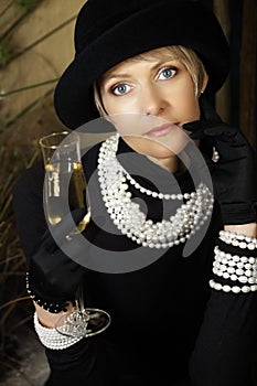 Woman in hat, pearls and champagne