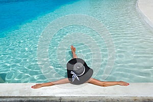 Woman in hat relaxing at the pool