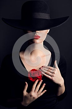 Woman in Hat, Rose Flower on Heart, Elegant Fashion Model Beauty Portrait on Black, Red Lips Hidden Eyes photo