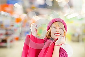Woman in hat and scarf shopping at supermarket