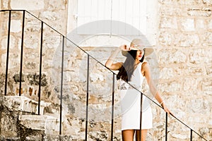 Woman with hat standing on the stairs outdoor