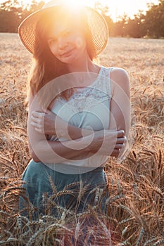 Woman with hat in summer field golden wheat, freedom concept. Happy girl enjoying life, colorful field with ripe