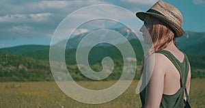 Woman with Hat in Sunny Mountain Field