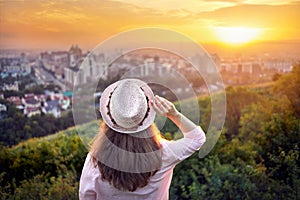 Woman in hat at sunset city view