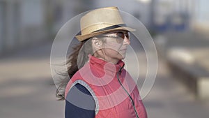Woman in hat in windy weather is thinking and enjoying the air.
