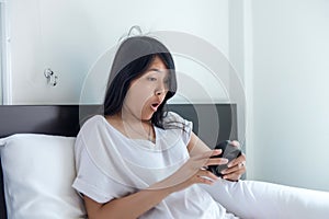 Woman hates getting stressed waking up early,Female stretching her hand to ringing alarm to turn off alarm clock