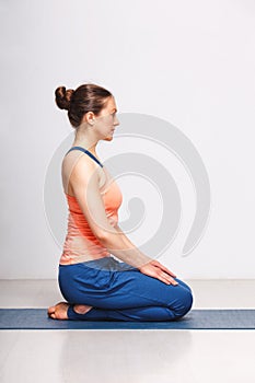 Woman in Hatha yoga asana Vajrasana