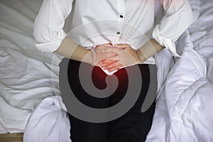 Woman have bladder or uti pain with vaginal problem sitting on bed in bedroom