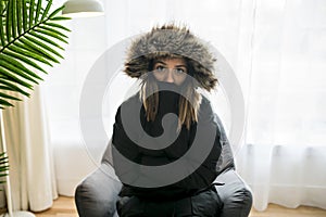 Woman have cold on the sofa at home with winter coat