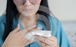 Woman have a coughing up blood and chest pain. Close up of hands holding tissue paper