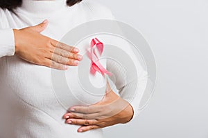 Woman she have pink breast cancer awareness ribbon on chest she hold breast by hand