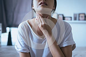 Woman have a sore throat,Female touching neck with hand,Healthcare Concepts photo