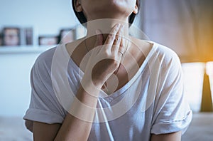Woman have a sore throat,Female touching neck with hand,Healthcare Concepts photo