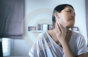 Woman have a sore throat,Female touching neck with hand,Healthcare Concepts photo