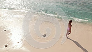 Woman have a walk on Maldives sandy beach, go swimming