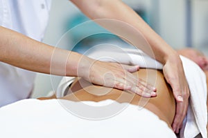 Woman having abdomen massage by professional osteopathy therapist