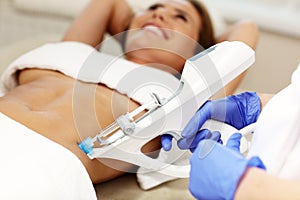 Woman having abdomen mesotherapy in beauty salon