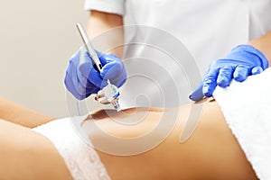 Woman having abdomen mesotherapy in beauty salon