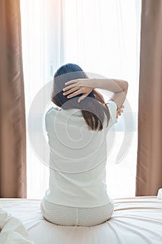 Woman having arm pain during sitting on bed at home, muscle injury and ache after waking up. Health and medical concept