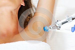 Woman having armpit mesotherapy in beauty salon