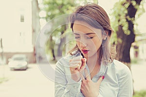 Woman having asthma attack or choking can`t breath suffering from respiration problems standing outdoors on a urban street