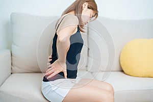 woman having back body ache during at home. adult female with muscle pain due to Piriformis Syndrome, Low Back Pain and Spinal
