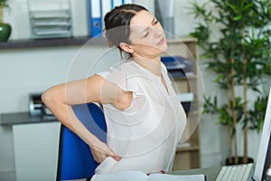 woman having back pain in office