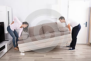 Woman Having Backpain While Lifting The Sofa